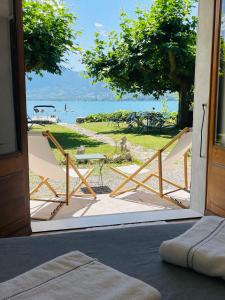 une porte ouverte avec vue sur la plage dans l'établissement Les Clapotis chambres pieds dans l eau lac d Annecy, à Angon
