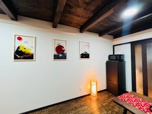 Habitación con nevera y algunas fotos en la pared. en 天王寺駅から徒歩7分 en Osaka