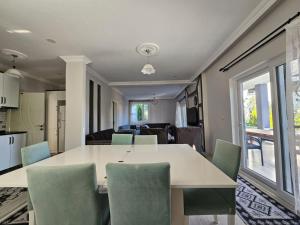 a kitchen and dining room with a table and chairs at Fethiye Merkez Villa in Karagedik
