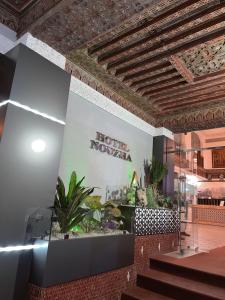 非斯的住宿－Hotel Nouzha，大堂设有酒店的新星标志和植物