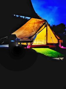 a lit up tent sitting on top of a field at Lakeview Glamping in Staro Myasto