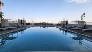 a large swimming pool with lounge chairs on a building at STAY BY LATINEM Luxury 1BR Holiday Home CVR A1410 near Burj Khalifa in Dubai