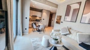 a living room with a white couch and a table at STAY BY LATINEM Luxury 1BR Holiday Home CVR A1410 near Burj Khalifa in Dubai