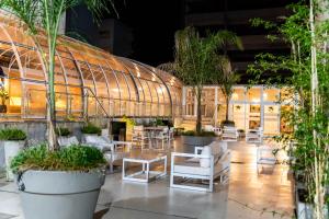 a patio with tables and chairs and a building at O2 Hotel Mar del Plata in Mar del Plata