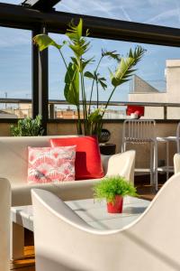 a table and chairs on a balcony with a plant at Hotel America Barcelona in Barcelona