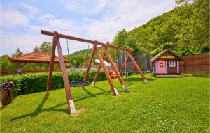 Une balançoire en bois est installée dans une cour avec une petite maison. dans l'établissement 2 Bedroom Cozy Home In Hrastovica, 