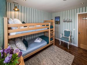 a bedroom with two bunk beds and a chair at Two Seas Hebrides in Eoropie