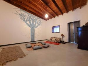 FirgasAcoran Family Guests House Firgas with Included Morning Yoga Practice的客厅墙上挂着一棵树的壁画