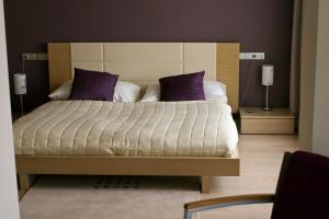 a bedroom with a large bed with purple pillows at Modrá Stodola contactless check-in in Horoměřice