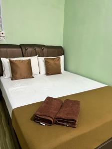 ein Bett mit zwei Handtüchern darüber in der Unterkunft Perhentian Mama's in Perhentian Island