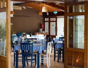 una sala da pranzo con tavoli e sedie blu e bianchi di Basilica Holiday Resort a Paphos