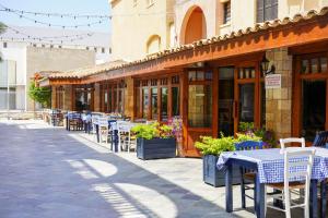 una fila de mesas y sillas fuera de un edificio en Basilica Holiday Resort en Pafos