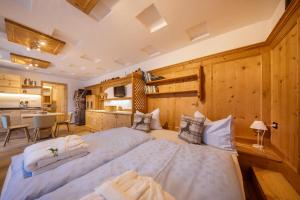 two beds in a room with wooden walls at Cesa dele Angele in Colle Santa Lucia