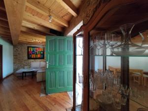 a room with a green door and a living room at Espaciosa casa de aldea, arte y descanso in Fisterra +25 photos