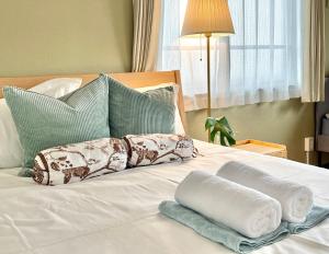 łóżko z ręcznikami i poduszkami w obiekcie 东京新宿区早稻田地铁步行5分钟Viewing House w Tokio
