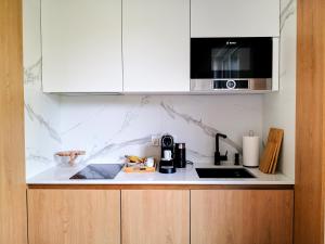 eine Küche mit einer Arbeitsplatte und einer Mikrowelle in der Unterkunft Apartament premium Green Dune w Porto Łeba in Łeba