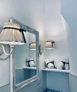 um espelho na casa de banho com toalhas nas prateleiras em La Casa Di Ada E Gigi Vacanze em Porto Cesareo