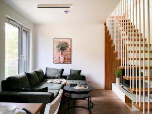 ein Wohnzimmer mit einem Sofa und einem Tisch in der Unterkunft Apartament premium Green Dune w Porto Łeba in Łeba