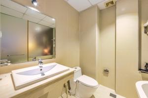 een badkamer met een wastafel, een toilet en een spiegel bij The Noble Swan Central Dong Du Hotel in Ho Chi Minh-stad