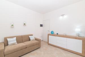 a living room with a couch and a tv at Appartamento Rosmarino In The City Center - Happy Rentals in Santa Teresa Gallura +16 photos