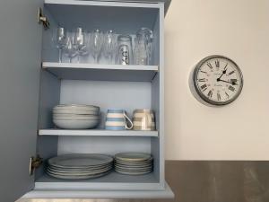 a shelf with plates and a clock on a wall at Beautiful Brighton Home in Brighton & Hove