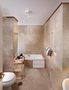 a bathroom with a tub and a toilet and a sink at Marina Real 2434 in Manilva