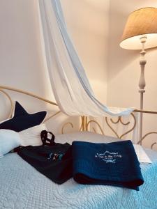 a bed with a blue blanket and shoes on it at La Casa Di Ada E Gigi Vacanze in Porto Cesareo
