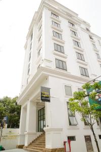 een groot wit gebouw met een trap ervoor bij TQ Hotel & Apartment in Hai Phong