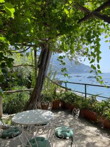 uma mesa e cadeiras com vista para a água em La Dolce Vita a Positano boutique hotel em Positano