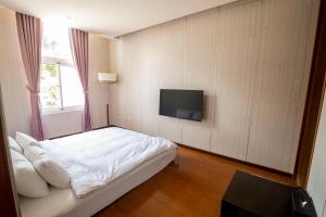 a bedroom with a bed and a tv on a wall at 水漾月明度假文旅 in Touwu