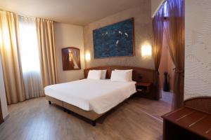 a bedroom with a bed and a painting on the wall at Welcome Hotel in Legnano