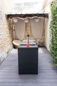 a table with plates on it on a patio at Coquette maison & extérieur in Cognac
