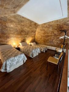 Una habitación con dos camas y una silla dentro. en AL DUOMO, Dimora Storica, en Matera