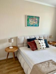 a living room with a white couch with pillows at Sunny apartment in Bellicity complex in Ravda