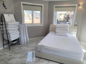 1 dormitorio con 1 cama con sábanas y almohadas blancas en Leve de Mongdol Pension en Geoje 