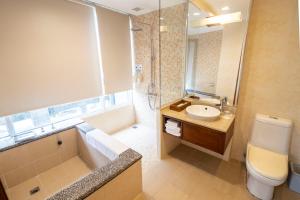 ein Badezimmer mit einem Waschbecken, einer Badewanne und einem WC in der Unterkunft 水漾月明度假文旅 in Touwu