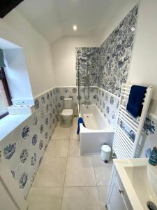 ein Badezimmer mit einer Badewanne, einem WC und einem Waschbecken in der Unterkunft Polrunny Farm Elderberry Cottage with sea view in Boscastle
