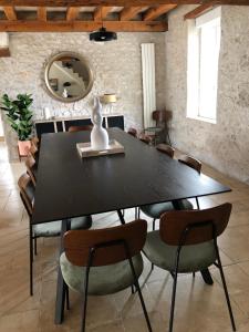 a dining room with a black table and chairs at La Maison de Zoé in Saint-Denis-sur-Loire