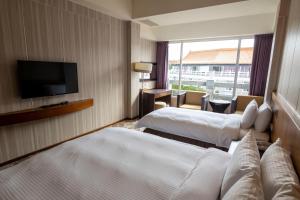 Touwuにある水漾月明度假文旅のベッド2台、薄型テレビが備わるホテルルームです。