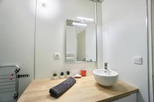La salle de bains est pourvue d'un lavabo et d'un miroir sur un comptoir. dans l'établissement Heol * plage à 100m*, à Larmor-Plage