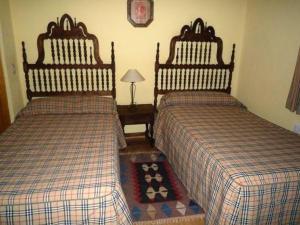 1 dormitorio con 2 camas y mesa con lámpara en Casa Abilio, en Villatoro