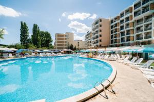 een groot zwembad met ligstoelen en een hotel bij Hotel Delfin - All Inclusive in Sunny Beach