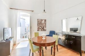 Un comedor con una mesa de madera y sillas amarillas. en Dimora Luxury con Terrazza - Centro Storico Ostuni, en Ostuni