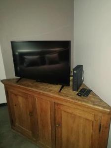 a flat screen tv sitting on top of a wooden cabinet at Mégi des Aguesses in Andenne