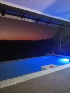 a blue swimming pool under a pergola at night at Hazyview Bogarts Villa in Hazyview