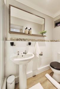y baño con lavabo, aseo y espejo. en 10 on Gillian Self-catering Apartments - NOT AFFECTED BY LOADSHEDDING, en Eversdal