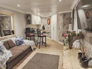sala de estar con sofá y cocina en 10 on Gillian Self-catering Apartments - NOT AFFECTED BY LOADSHEDDING, en Eversdal