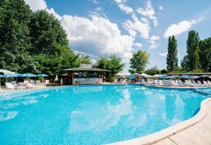 een groot zwembad met stoelen en parasols bij Hotel Delfin - All Inclusive in Sunny Beach