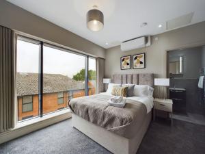 um quarto com uma cama e uma grande janela em Adelaide Apartment on Lisburn Road by Lesley em Belfast