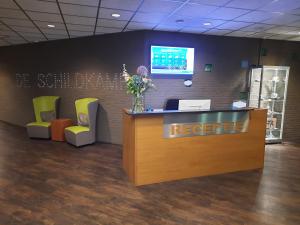 a reception desk in an office with a reception counter at Hotel De Schildkamp in Asperen